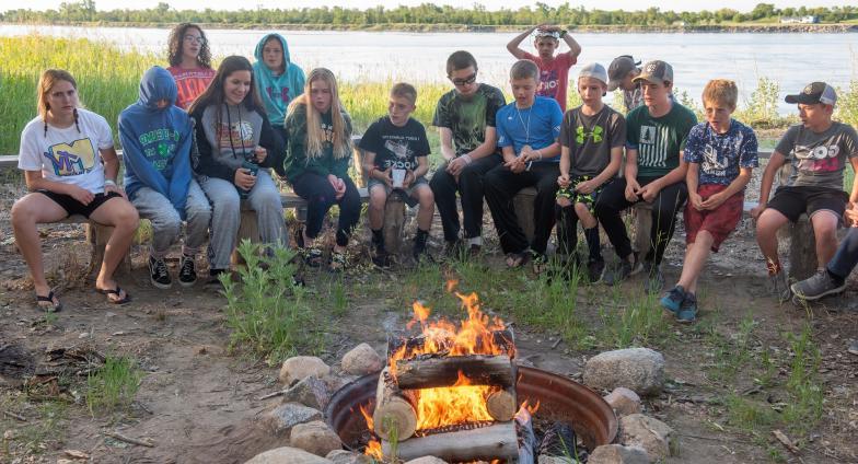 4H camp kids sitting around campfire