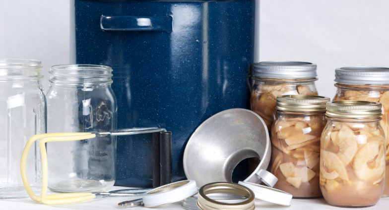 jars of canned fruit slices with water bath canner and canning equpment