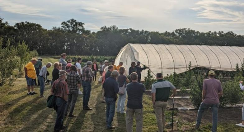 People having a discussion outside a greenhouse