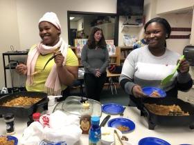 three women preparing food in electric skillets