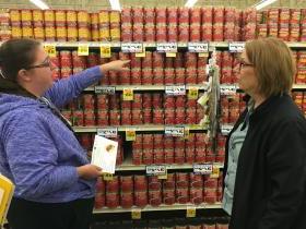 two women looking at canned tomato products